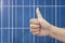 Thumb up on a solar panels background. Photovoltatic power industry.