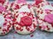 Thumbprint cookies decorated for Valentineâ€™s Day on a rustic silver tray, coated with frosting, and red, white and pink