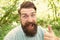 Thumbs up for bearded and beardy. Bearded man giving thumbs up hand gesture on natural landscape. Bearded hipster