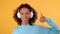 Thumbs up! close-up, female portrait, Young smiling woman in big white wireless headphones shows her thumbs up. Isolated