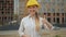 Thumbs up! Confident joyful female architect in a hard hat looking at the camera and showing thumbs up. 4Ð›