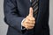 Thumbs up - hand of businessman held in front of body