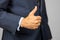 Thumbs up - hand of businessman held in front of body