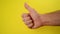Thumbs Up For Like, male hand endorsing over yellow background