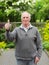 Thumbs up old man in garden