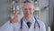 Thumbs Up by Positive Doctor with Grey Hairs