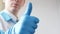 Thumbs up symbol by smiling young confident doctor.