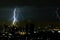 Thunder storm lighting bolt on the horizontal sky and city scape