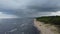 A thundercloud is approaching with rain over the sea. perspective view of coastline from drone