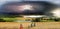 Thundercloud, lightning and rain above the pond and wheat fields