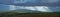 Thundercloud and rays of the sun on a mountain in mountainous forests panorama