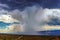 Thunderhead cloud produces rain shower over semi-desert grassland prairie