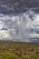 Thunderhead cloud produces rain shower over semi-desert grassland prairie