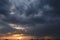 Thunderous heavy dark clouds and rain in the distance at sunset