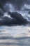 Thunderstorm clouds texture. Storm sky with dark grey and white cumulus clouds against blue sky