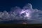 Thunderstorm illuminated by lightning in the night sky