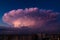 Thunderstorm in shape of explosion over the city on a warm summer evening. Cumulonimbus Incus cloud in a shape of nuclear mushroom