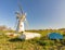 Thurne Mill and small boats in the Norfolk countryside on a bright and sunny day