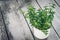 Thyme bunch. Bundle of fresh thymes in a Rustic enameled mug on a wooden background. Copy space.