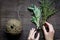 Thyme and sage on wooden background with hands top view