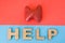 Thyroid gland with Help word. Anatomical model of thyroid gland is on red background, below letters that make word Help on blue ba