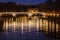 Tiber River, bridge and reflections on water. Night Rome, Italy.