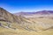 Tibet landscape showing a road through the mountains on a blue sky day, near the city of Lhasa.