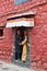 Tibet, Lhasa, China, June, 03, 2018.  Young couple of people in national costumes standing in the doorway of ancient monastery and