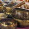 Tibetan healing singing bowls with selective focus to one with mantra sanskrit engraving pattern.