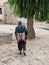 Tibetan man with braids in traditional clothes walking near the Sera monastery, Lhasa, Tibet, China