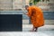 tibetan monk taking a picture of fountain on a place