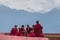 Tibetan monks rest at upper level of Rumtek Monastery near Gangtok with Himalayas mountains on background, Sikkim, India