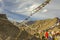 A Tibetan prayer flags in the sky against the backdrop of the Himalayan desert mountains.