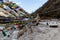 Tibetan prayer flags waving and swaddled in sideway with white car over frozen river at Thangu and Chopta valley in winter.