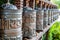 Tibetan prayer wheels, cylindrical rolls on a spindle made from metal and wood, selective focus