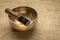 Tibetan singing bowl with a mallet on a textured bark paper, sound therapy for healing, relaxation and meditation