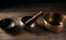 Tibetan singing copper bowl with a wooden clapper on a brown wooden table, objects for meditation