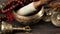 Tibetan singing copper bowl with a wooden clapper on a brown wooden table, objects for meditation and alternative medicine