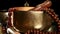 Tibetan singing copper bowl with a wooden clapper on a brown wooden table, objects for meditation and alternative medicine