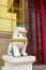 Tibetan snow lion with turquoise mane in front of entrance to Buddhist temple. Symbol of snow Himalayan mountains and sky