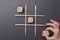 Tic tac toe game with sushi on dark black background, creative concept sushi rolls. Banner, playing tic tac toe game