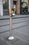 Ticket purchase validation point machine on metal pole on pavement for public transport.  Pride rainbow symbol on top