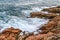 Tidal bore. Foamy blue waves crashing on coastal cliffs