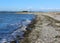 Tidal waves bring seaweed to a rocky beach