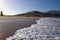 Tide foam on sandy beach