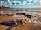 Tide lapping on the beach with lighthouse in background