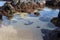 Tide pools formed on Paia Bay enclosed by large volcanic boulders in Maui, Hawaii