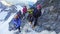 Tied climbers climbing tied with a rope with ice axes and helmets