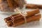 Tied dried cinnamon sticks on rustic white wooden table - selective focus