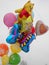 Tied and fluttering in the wind children`s helium balloons. An inflated bear, a beautiful butterfly, yellow, pink, orange, red,